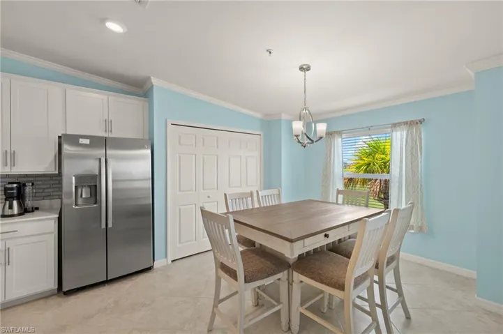 Dining area with a chandelier, baseboards, ornamental molding, and light tile patterned floors