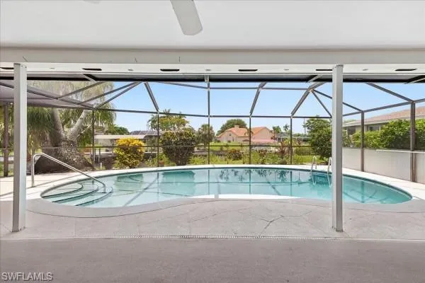 View of swimming pool featuring glass enclosure