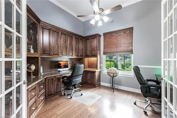 Home office featuring ceiling fan, french doors, and light hardwood / wood-style floors