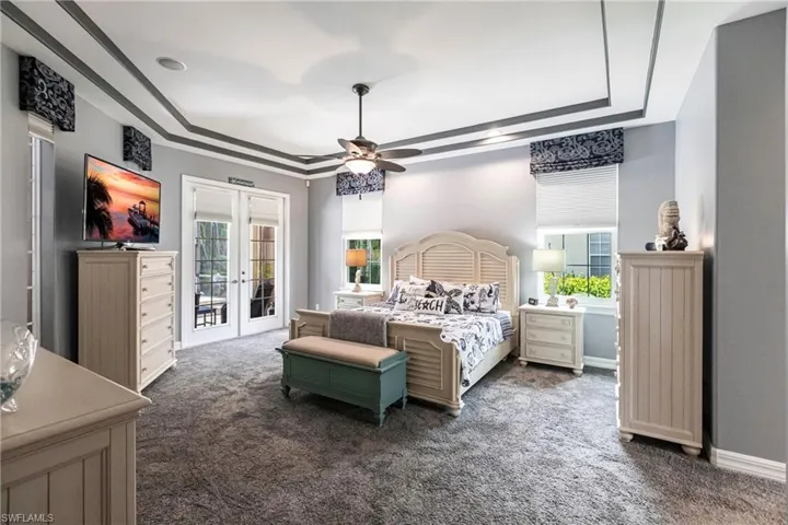 Bedroom with carpet, access to outside, ceiling fan, french doors, and a tray ceiling