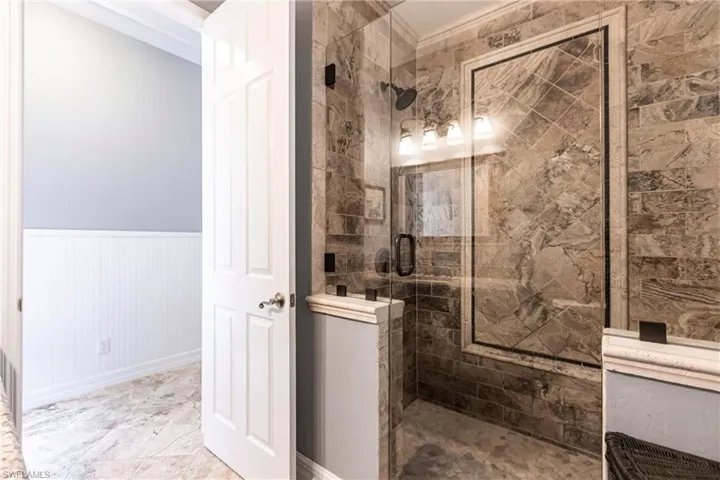Full Pool Bathroom featuring crown molding, walk in shower, and tile patterned flooring