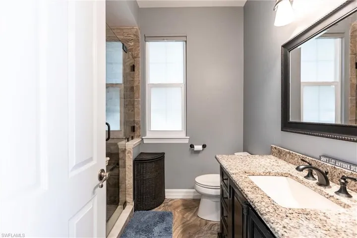Full Pool Bathroom with a shower with door, vanity, plenty of natural light, and toilet