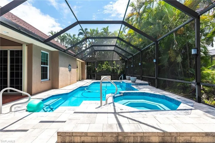 View of swimming pool featuring a lanai, an in ground hot tub, and a patio area