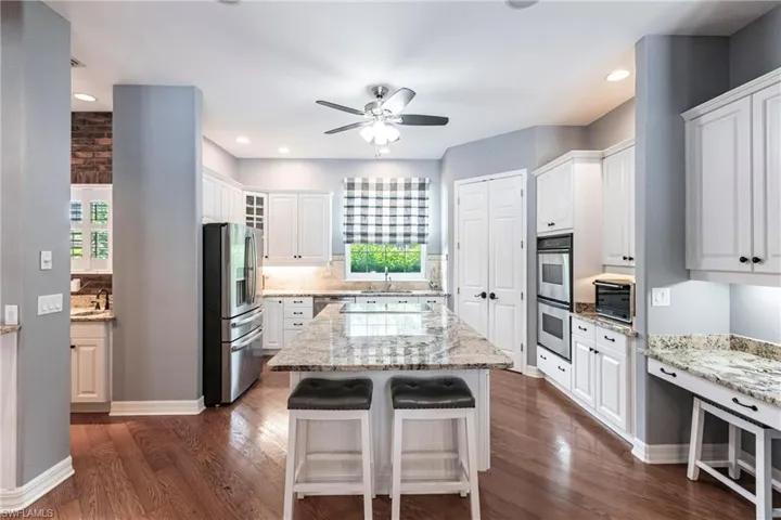 Kitchen with appliances with stainless steel finishes, dark wood-type flooring, a kitchen island, and a healthy amount of sunlight