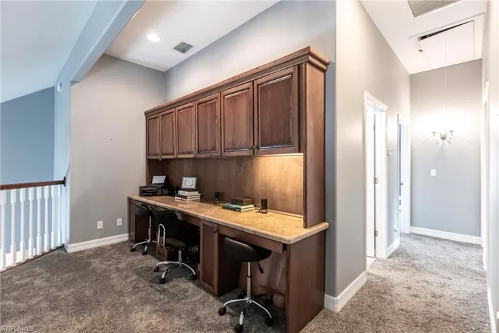 Carpeted office with vaulted ceiling
