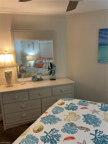 Bedroom featuring a built-in ceiling fan, light-toned walls, and wood-finish flooring