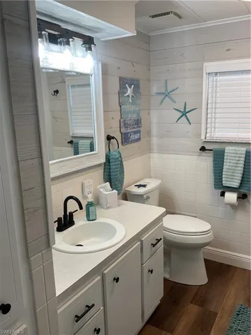 Bathroom featuring a white vanity with integrated sink, matte black faucet, and coordinating hardware