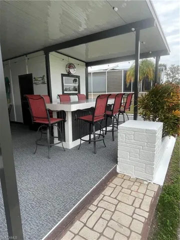 Covered outdoor entertaining area featuring a built-in bar with seating