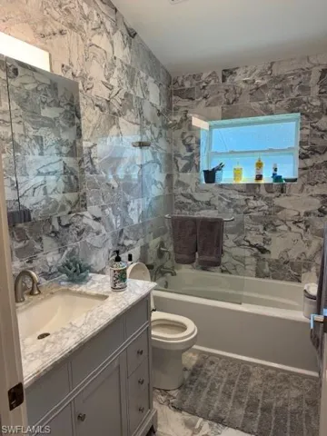 Full bathroom with vanity, toilet, and tub / shower combination