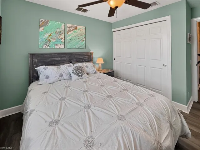 Bedroom featuring dark wood finished floors, a closet, and ceiling fan