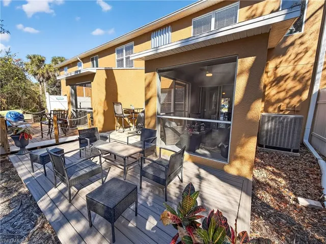 View of patio / terrace with a sunroom, a wooden deck, and an outdoor living space