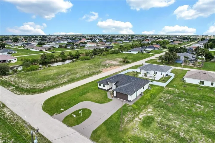 Aerial perspective of suburban area featuring a nearby body of water