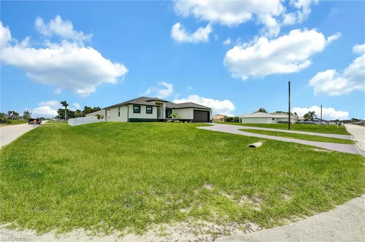 View of front of property featuring concrete driveway, a garage, stucco siding, and a front yard