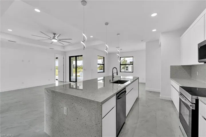 Kitchen featuring appliances with stainless steel finishes, a spacious island, white cabinetry, recessed lighting, and modern cabinets
