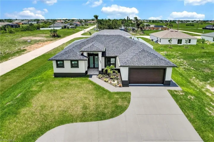 View of front of house featuring roof with shingles, a garage, stucco siding, and a residential view