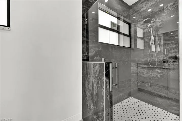 Full bath with a marble finish shower