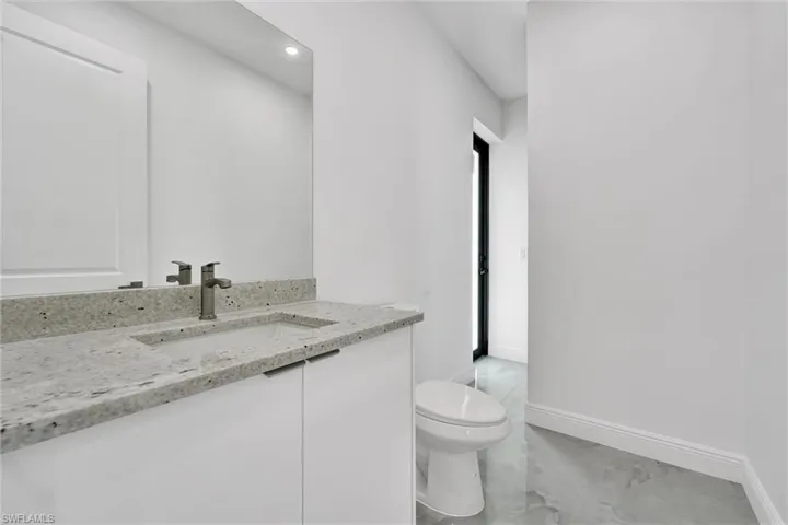 Half bathroom with vanity and recessed lighting