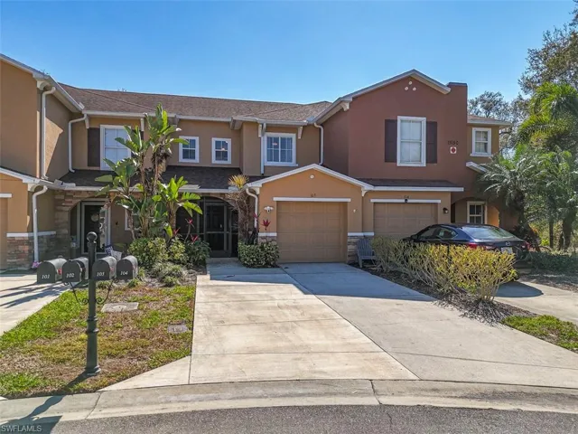 View of front facade featuring stucco siding, concrete driveway, stone siding, and an attached garage