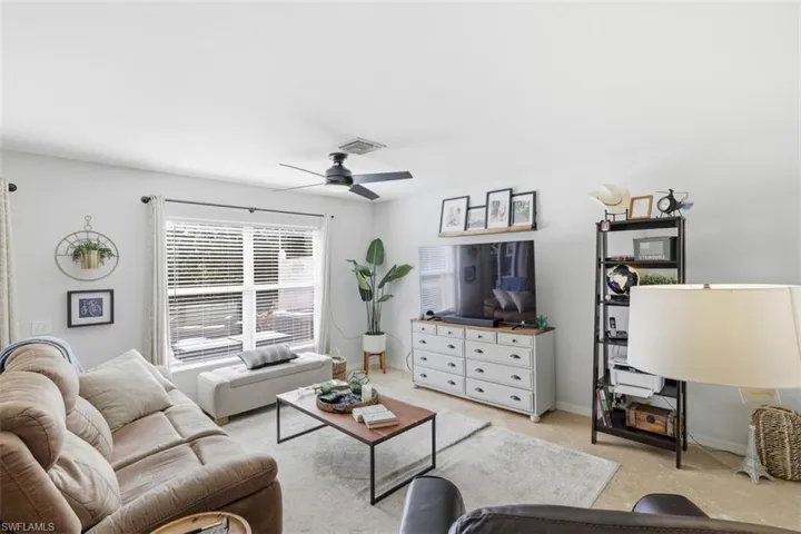 Living area with ceiling fan and baseboards