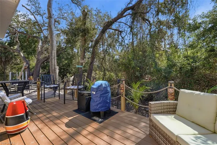 Wooden terrace with a grill and an outdoor lounge area