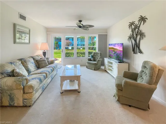 Living area featuring ceiling fan and light carpet