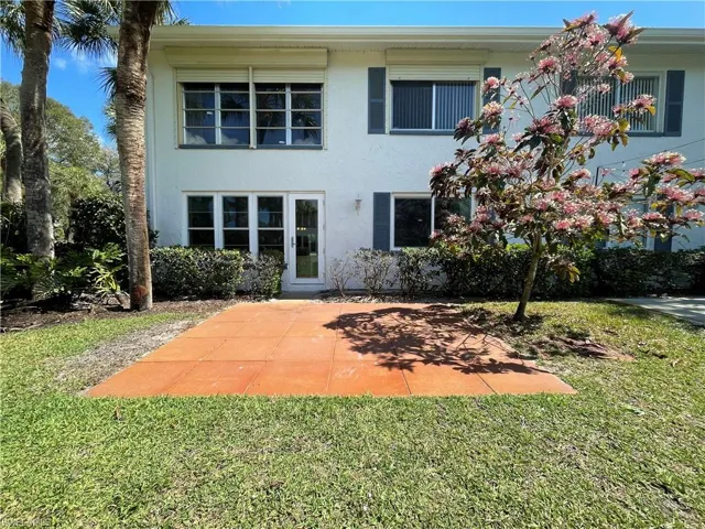Rear view of property with stucco siding and a lawn
