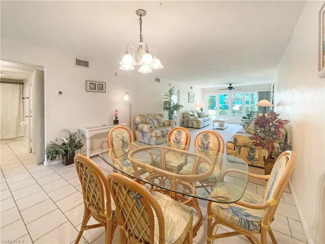 Dining space with suspended lighting, a ceiling fan, and light tile patterned floors