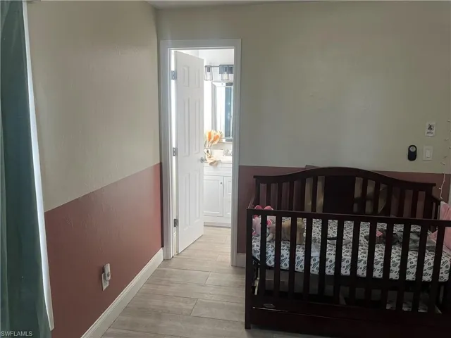 Bedroom featuring wood finished floors and a crib