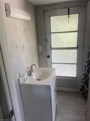 Full bath with vanity and light wood-type flooring
