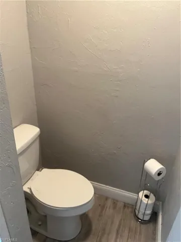 Bathroom with light wood-style flooring and a textured wall