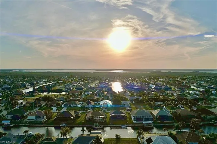 Aerial view at dusk featuring a water view
