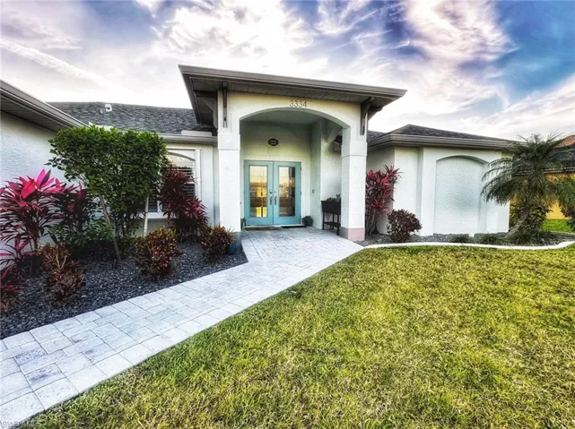 Property entrance with french doors and a lawn