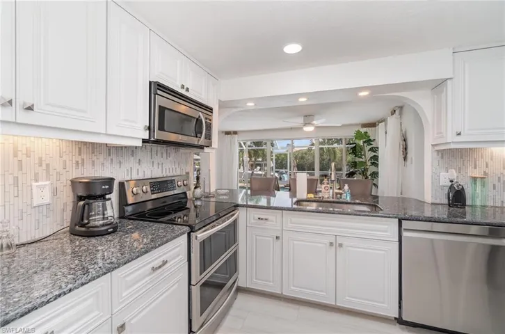 Kitchen with white cabinetry, stainless steel appliances, and sink