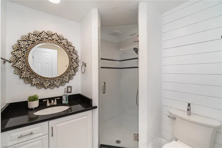 Bathroom with vanity, toilet, and an enclosed shower