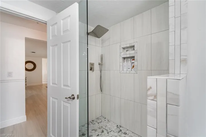 Bathroom featuring a tile shower and hardwood / wood-style flooring
