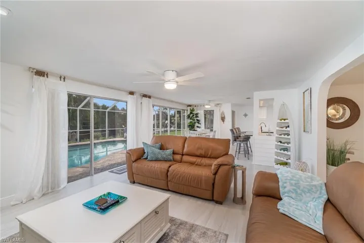 Living room with ceiling fan and light hardwood / wood-style flooring