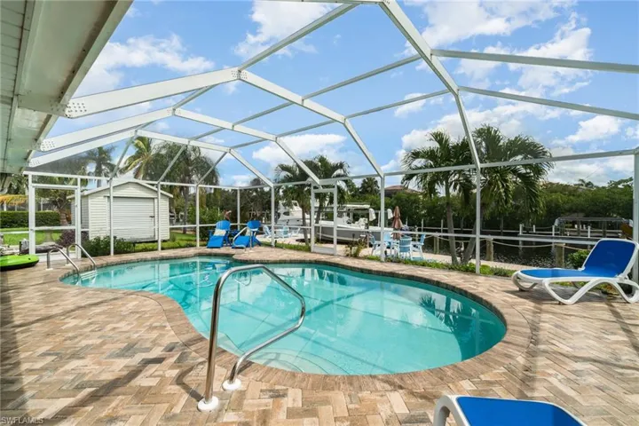 View of swimming pool with a patio area, a lanai, and a storage unit