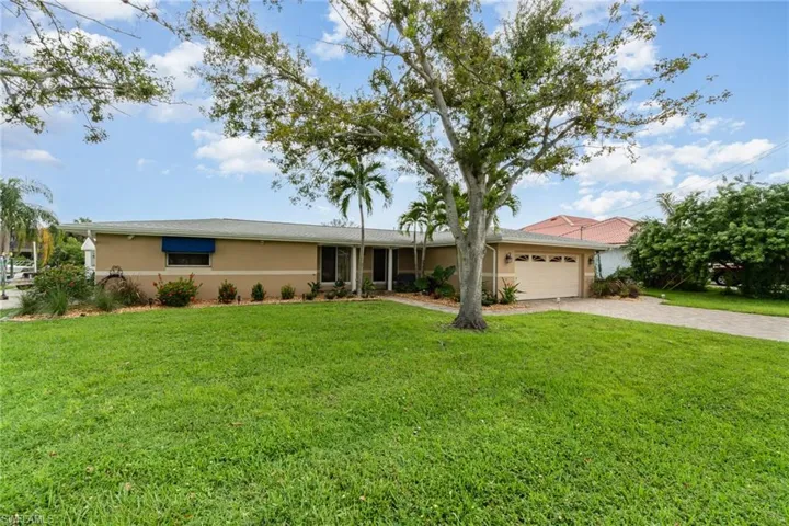 Single story home featuring a front yard and a garage