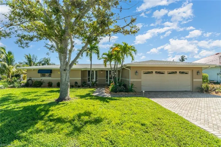 Ranch-style home featuring a front lawn and a garage