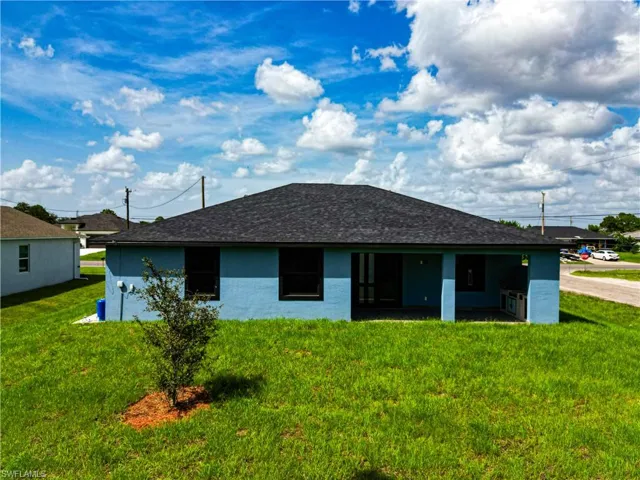 Rear view of house featuring a yard