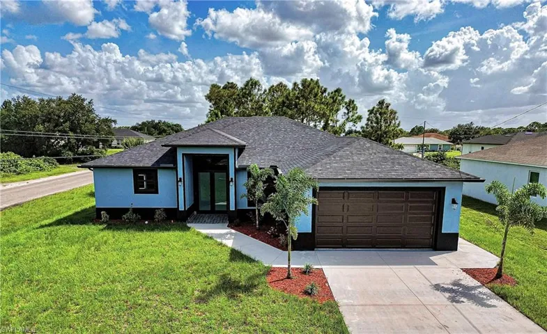View of front of home with a front lawn and a garage