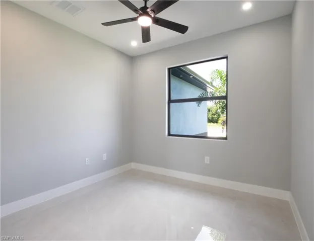 Spare room with ceiling fan and light tile patterned floors