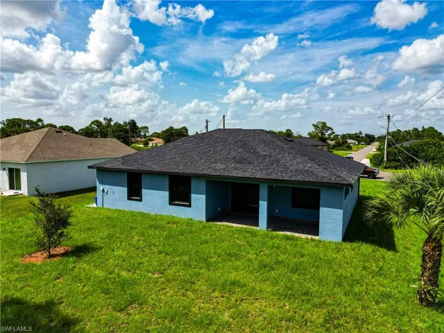 Rear view of property with a lawn