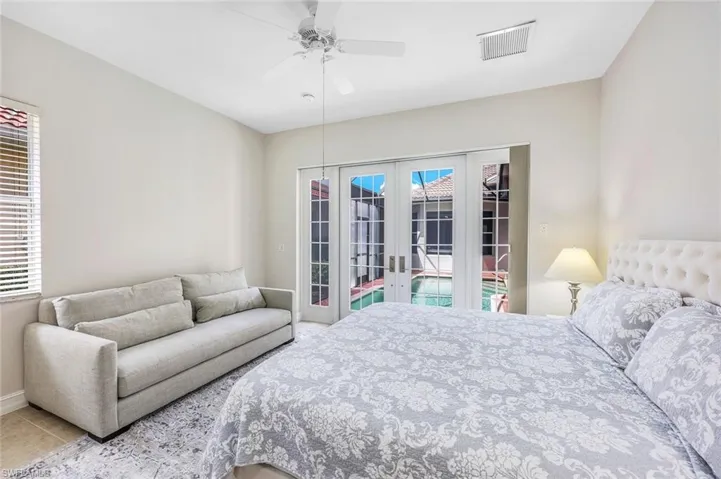 Tiled bedroom featuring french doors, access to exterior, and ceiling fan