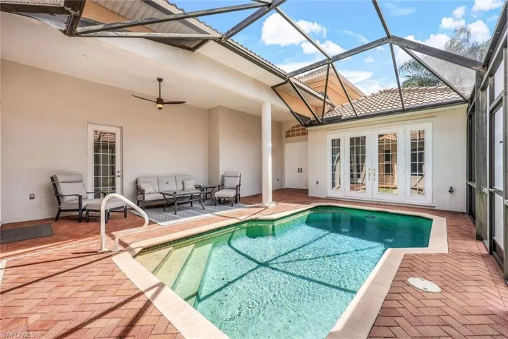 View of swimming pool with a patio area, french doors, and glass enclosure