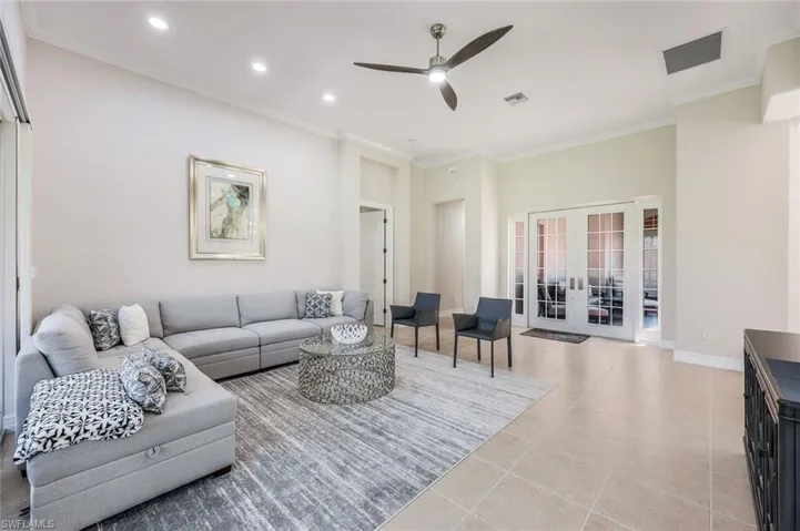 Tiled living room featuring crown molding, french doors, and ceiling fan