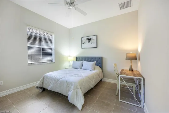 Bedroom with tile patterned flooring and ceiling fan