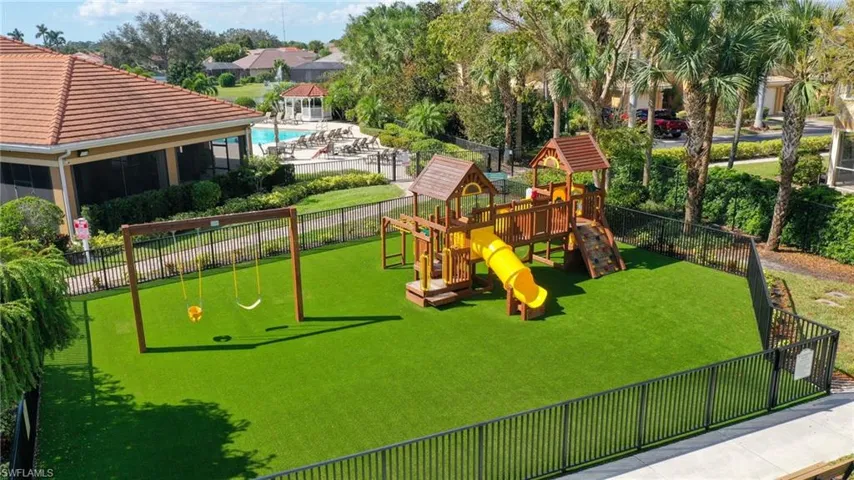 View of playground featuring a yard and a community pool