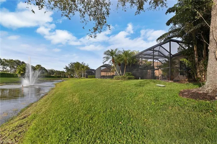 View of yard with a lanai and a water view