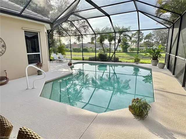 View of pool featuring a patio area and glass enclosure